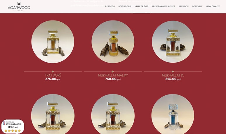 Un site Web affichant six flacons de parfum de oud luxueux avec des prix sur fond rouge.