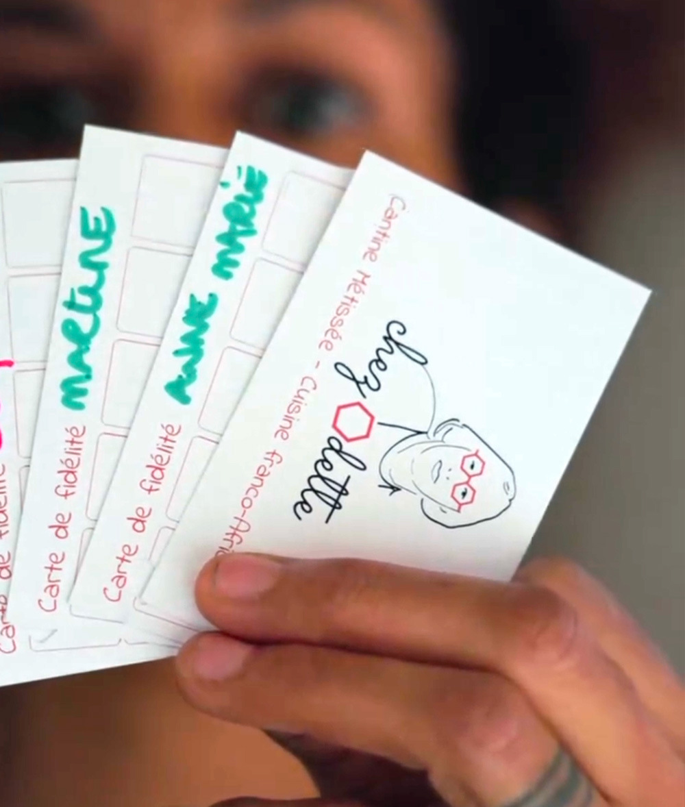 Une main tenant quatre cartes de fidélité, dont l'une comporte une illustration du visage d'une femme et le texte "Joye Jolie". Limbus Studio