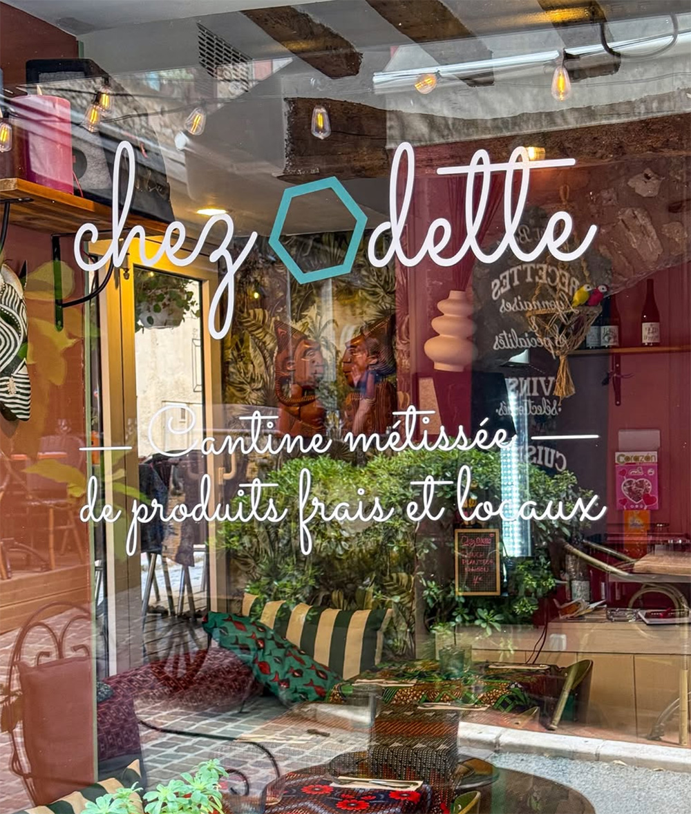 Vitrine de restaurant avec "chez Odette" et "Cantine métissée de produits frais et locaux" en écriture blanche. Limbus Studio