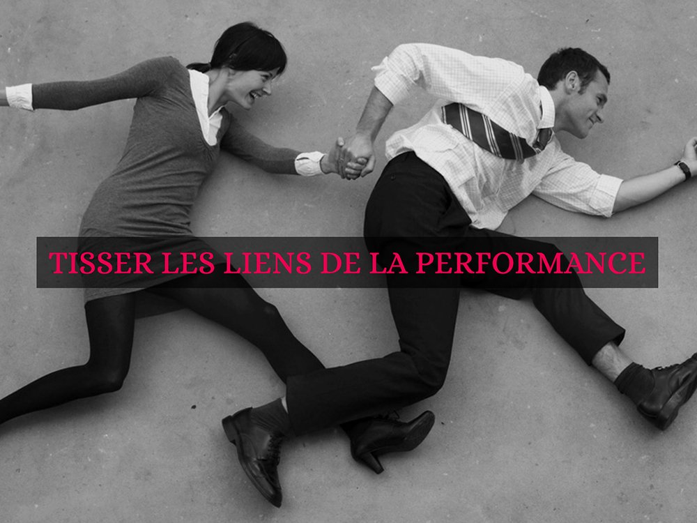 Un homme et une femme en tenue de bureau sont allongés sur le sol, se tenant la main, incarnant l'essence de la « création et du design ». Le texte en français dit « Tisser les liens de la performance », capturant une synergie harmonieuse. Limbus Studio