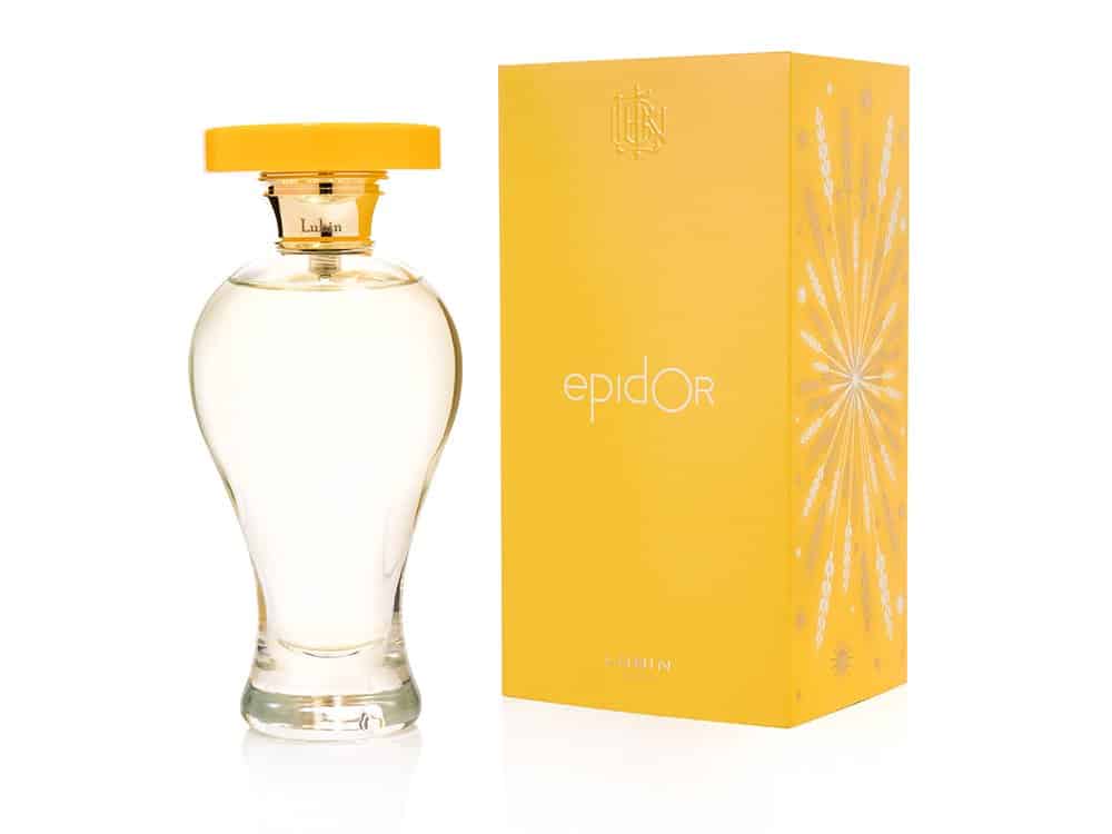 Un flacon de parfum Epidor de Lubin avec un bouchon jaune, présenté à côté d'une boîte jaune assortie ornée d'accents argentés, présente un exemple frappant de design sophistiqué et de graphisme méticuleux. Limbus Studio